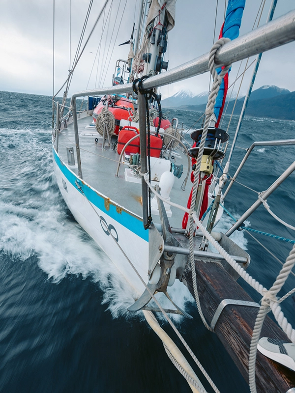 Segurança do Veleiro Ksar O Veleiro Ksar se destaca pela sua segurança a bordo! O Veleiro Ksar: O Barco Mais Seguro para Navegações Austrais na Terra do Fogo. O Veleiro Ksar se destaca como o barco mais seguro para explorações nas águas austrais. Equipado com a mais recente tecnologia em segurança, garante proteção em cada travessia. Além disso, conta com sistemas de comunicação avançados, incluindo internet via satélite Starlink da SpaceX. Seu robusto design de casco de aço e isolamento térmico avançado o tornam ideal para enfrentar os desafios do clima antártico, assegurando uma navegação segura e confortável. Veleiro Ksar e sua Segurança Os elementos de segurança do Veleiro Ksar são cruciais para garantir uma navegação segura em condições extremas. Equipado com coletes salva-vidas infláveis, cintos de segurança, botes salva-vidas e extintores, o Ksar oferece proteção integral. Seu avançado sistema de comunicação, incluindo internet via satélite Starlink, e seu robusto design garantem que a tripulação esteja protegida e conectada o tempo todo, enfrentando com confiança os desafios do clima austral. Coletes Salva-Vidas No Veleiro Ksar, a segurança é primordial, e contamos com dois tipos de coletes salva-vidas para atender a diversas necessidades. Coletes Infláveis Automáticos: Estes coletes são leves e compactos, projetados para se inflar automaticamente ao contato com a água, graças a um cartucho de CO2. Oferecem uma flutuação rápida e efetiva e têm alta visibilidade com cores brilhantes e refletores. São ideais para condições adversas e garantem uma flutuação rápida em emergências. Coletes Salva-Vidas Tradicionais de Espuma: Embora menos compactos, estes coletes proporcionam uma flutuação confiável e constante. Feitos de espuma resistente, oferecem conforto e segurança durante a navegação. São uma opção robusta e efetiva para quem prefere uma solução mais tradicional e sempre visível. Anéis de Flotação Salvavidas de Emergência: Estes anéis estão disponíveis ao longo do veleiro, equipados com linhas de resgate. Estão projetados para serem lançados rapidamente em caso de queda ao água, oferecendo uma flutuação imediata e um ponto de apoio para o resgate. Esses equipamentos garantem que a tripulação do Ksar esteja protegida o tempo todo, proporcionando múltiplas camadas de segurança durante nossas travessias. Balizas e Sinalizadores de Localização O Veleiro Ksar está equipado com um arsenal completo de elementos de segurança para garantir uma navegação segura em condições extremas. Entre eles, destacamos: Balizas de Emergência (EPIRB): Nosso veleiro conta com uma EPIRB (Emergency Position Indicating Radio Beacon) que emite um sinal de emergência para localização precisa em caso de necessidade. Esta baliza garante que possamos ser localizados rapidamente pelos serviços de resgate em qualquer situação crítica. Sinalizadores de Emergência: Bengalas com Paraquedas: Estas bengalas estão projetadas para lançar sinais luminosos do ar, visíveis a grandes distâncias, mesmo em condições adversas. São essenciais para marcar a posição em situações de emergência e facilitar o resgate. Bengalas de Mão: Utilizadas para emitir sinais de emergência visíveis durante o dia e a noite. São fáceis de manusear e fornecem um sinal direto de alerta. Bengalas de Fumaça: Ideais para situações em que é necessária sinalização de emergência em condições de visibilidade limitada, como neblina ou chuva. Geram uma coluna densa de fumaça para visibilidade prolongada. Lanterna de Emergência: Equipado com lanternas de emergência, o Ksar garante que sempre haja uma fonte de luz disponível para navegação noturna ou em condições de baixa visibilidade. Estas lanternas são robustas e confiáveis, garantindo visibilidade e comunicação o tempo todo. Esses equipamentos avançados garantem que o Veleiro Ksar esteja preparado para qualquer emergência, proporcionando múltiplas opções para comunicação e sinalização em situações críticas. Apitos e Linha de Vida de Segurança Apitos de Emergência: Cada membro da tripulação e passageiro a bordo do Ksar tem acesso a apitos de emergência de alta potência. Estes dispositivos são fundamentais para sinalização acústica em caso de emergência, permitindo uma comunicação clara e rápida em condições adversas, como neblina ou tempestade. Sinalizam a ajuda para serem ouvidos a grandes distâncias, facilitando o resgate. Linha de Vida de Segurança e Cintos de Segurança: O Veleiro Ksar está equipado com linha de vida de segurança e cintos de segurança de alta qualidade. Estes sistemas de fixação são indispensáveis para a segurança na coberta, especialmente em condições de mar agitado. Os cintos são projetados para proporcionar conforto e liberdade de movimento, enquanto asseguram a tripulação, evitando quedas ao água. As linhas de vida às quais se prendem os cintos estão instaladas estrategicamente ao longo do veleiro, permitindo deslocamentos seguros em qualquer parte da embarcação. Equipamento de Primeiros Socorros Kit de Primeiros Socorros: Equipado com bandagens, gazes, fitas adesivas, curativos, antissépticos e desinfetantes para tratar cortes e feridas. Também inclui pinças, tesouras e luvas de látex, e talas para imobilizar fraturas. Treinamento e Preparação: A tripulação está treinada em primeiros socorros, garantindo uma resposta rápida e eficaz em emergências médicas. Equipamentos de Proteção Contra Incêndios No Veleiro Ksar, a segurança contra incêndios é essencial. Contamos com quatro extintores estrategicamente localizados e revisados regularmente, garantindo uma resposta rápida e eficaz em caso de emergência. Detector de Gás: Instalados em áreas-chave, esses detectores oferecem uma detecção precoce de gases, proporcionando alertas imediatos para tomar medidas preventivas. Detector de Monóxido de Carbono: Monitoram continuamente o ar, emitindo um alarme se detectarem níveis perigosos desse gás inodoro e potencialmente letal. Esses equipamentos garantem que qualquer ameaça seja detectada e controlada rapidamente, proporcionando tranquilidade e segurança durante nossas travessias em Ushuaia e Terra do Fogo. Bote Salvavidas e Dinghy Auxiliar Bote Salvavidas para 8 Pessoas: Projetado para emergências, nosso bote salva-vidas tem capacidade para 8 pessoas e está equipado com: Facão flutuante, preso ao bote por um cabo Anilha flutuante com corda de 30 metros Caderno de bordo e tabela de ações e instruções Tabela de sinais de salvamento Lanterna estanque com baterias e lâmpada de reserva Espelho de sinais 3 bengalas de sinalização 2 foguetes de sinalização com paraquedas 1 lata de fumaça de sinalização Comprimidos anti-náusea (Biodramina), 6 por pessoa Kit de primeiros socorros Mantas térmicas Âncora de capa com cabo de 30 metros Par de remos flutuantes e desmontáveis Bomba de água flutuante 2 esponjas para remoção de água Inflador de emergência Apito Além disso, conta com: 4 bolsas de lastro para estabilidade Fitas em todo o seu perímetro para facilitar o acesso Degrau inflável para facilitar o acesso Arco inflável com capota fechável com zíper Canalização na capota para coleta de água da chuva ou condensação Luz LED de posição com bateria Piso térmico Dinghy Auxiliar com Motor Fora de Borda: Para tarefas que requerem um bote menor, o Ksar conta com um dinghy auxiliar de 3 metros de comprimento, equipado com um motor fora de borda Yamaha de 5 HP. Este dinghy é ideal para operações como se aproximar da costa, realizar reparos menores e explorar áreas inacessíveis para o veleiro. Sua manobrabilidade e rapidez o tornam uma ferramenta valiosa para diversas atividades. Esses equipamentos reforçam nosso compromisso com a segurança e eficiência, garantindo que o Veleiro Ksar esteja preparado para qualquer situação durante nossas travessias pelos paisagens austrais de Ushuaia e Terra do Fogo. Equipamentos de Comunicação O Veleiro Ksar, o mais seguro de Ushuaia, está equipado com avançados equipamentos de comunicação, essenciais para navegar pelos paisagens inóspitos da Terra do Fogo. Rádios VHF de Emergência: O Ksar conta com quatro rádios VHF de emergência: dois fixos, um no interior do barco e outro no cockpit ao lado do leme, e dois portáteis submersíveis para desembarques em terra. Esses dispositivos permitem manter contato constante com outras embarcações e estações costeiras, facilitando a transmissão de alertas e solicitações de ajuda imediata, garantindo a segurança da tripulação e a eficiência das operações. Sistema de Comunicação via Satélite: Equipado com internet via satélite Starlink da SpaceX, o Ksar garante comunicação constante, mesmo nas áreas mais remotas da Terra do Fogo. Este sistema fornece acesso a e-mails, mensagens instantâneas e dados de navegação, permitindo atualizações em tempo real e comunicação contínua com serviços de emergência e apoio em terra. Sistema de Localização por GPS: O sistema de GPS instalado a bordo permite a navegação precisa e monitoramento contínuo da posição do veleiro. Em caso de emergência, o sistema facilita a localização rápida do Ksar, fornecendo coordenadas exatas para operações de resgate e apoio. Sistema de Monitoramento e Navegação Radar e Sonar: O Ksar está equipado com radar de alta resolução e sonar, essenciais para detectar obstáculos submersos e monitorar condições climáticas adversas. Esses sistemas melhoram a segurança e a precisão durante a navegação em águas remotas e desafiadoras. Equipamento de Navegação e Monitoração: Inclui instrumentos de alta precisão para o controle e monitoramento das condições de navegação, como bússolas, anemômetros e barômetros. Esses dispositivos garantem uma navegação segura e eficiente, ajustando a rota conforme necessário para evitar perigos e otimizar o percurso. Sistema de Alarme e Detecção de Incêndio Sistema de Alarme de Incêndio: Equipado com sensores de fumaça e calor em áreas críticas, o sistema de alarme garante uma resposta rápida em caso de detecção de fumaça ou aumento de temperatura, acionando alarmes sonoros e visuais para alertar a tripulação e permitir a ação imediata. Extintores de Incêndio: Com quatro extintores estrategicamente localizados a bordo, o Ksar está preparado para enfrentar qualquer risco de incêndio. Os extintores são revisados regularmente e são compatíveis com diferentes tipos de incêndios, garantindo uma resposta eficaz e segura. Equipamentos de Segurança Adicionais Máscaras de Respiração e Kits de Oxigênio: O Ksar está equipado com máscaras de respiração e kits de oxigênio para situações de emergência que envolvam fumaça ou falta de oxigênio. Esses equipamentos garantem a proteção respiratória da tripulação e passageiros, assegurando a capacidade de lidar com condições adversas. Roupas e Equipamentos de Proteção: Inclui roupas impermeáveis e quentes, luvas e botas, para proteger a tripulação em condições meteorológicas extremas. Além disso, os equipamentos de proteção garantem o conforto e a segurança durante as operações no mar e a bordo. Com todos esses recursos, o Veleiro Ksar oferece um ambiente seguro e protegido para explorar as paisagens imersivas da Terra do Fogo e além.